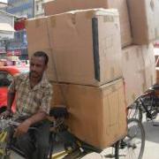 rickshaw puller pulling large boxes upon large boxes