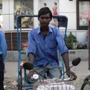 frontal view of rickshaw puller wearing long sleeved blue shirtin Delhi