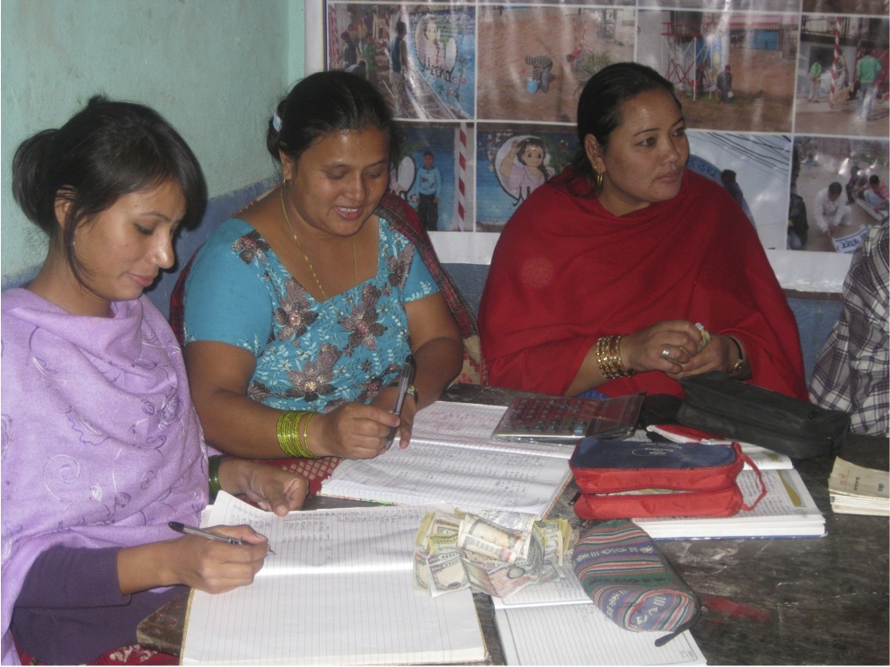 3 women sitting at a table going through paperwork